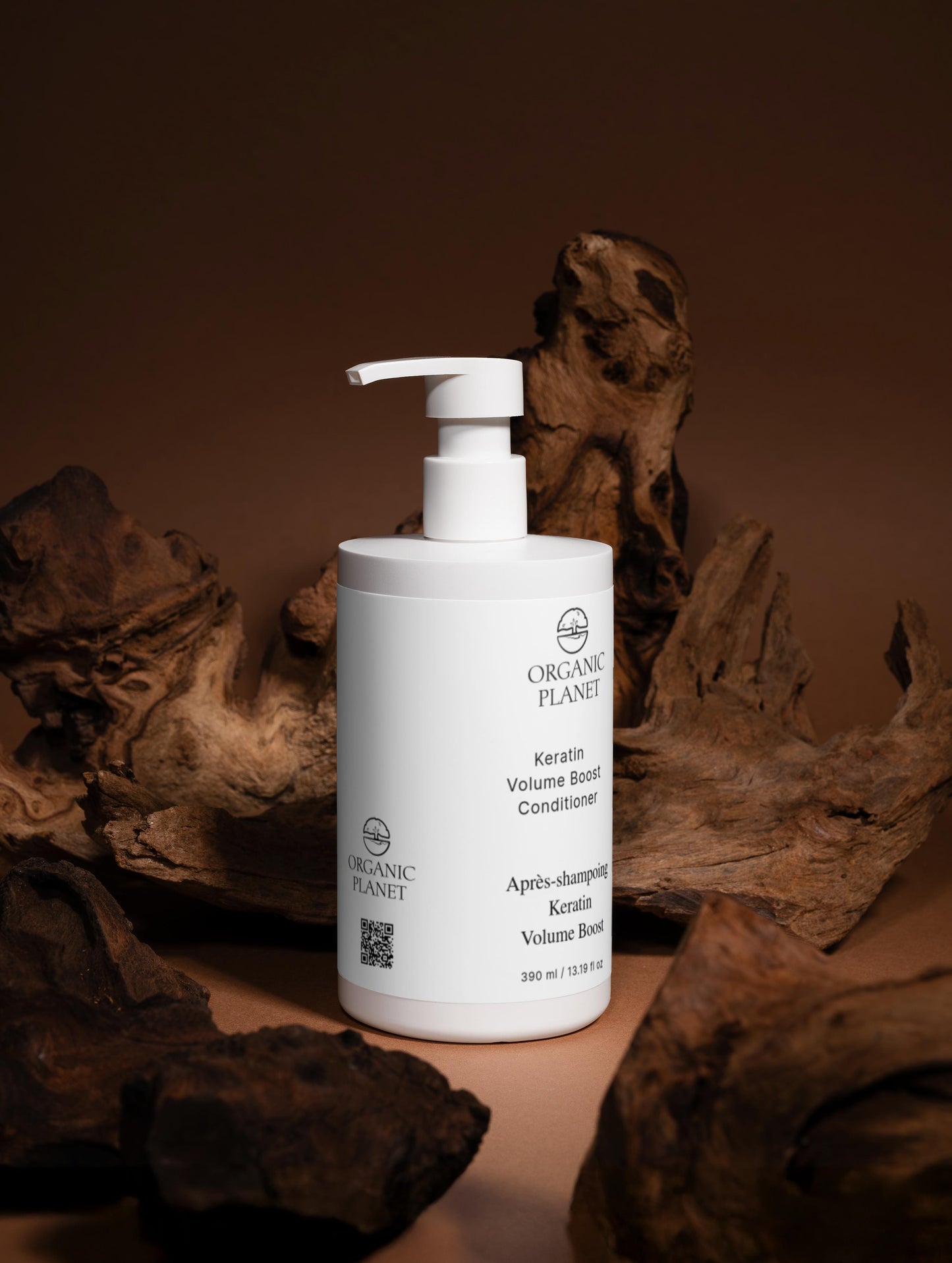 White bottle of Organic Planet conditioner on a brown background with organic elements.
