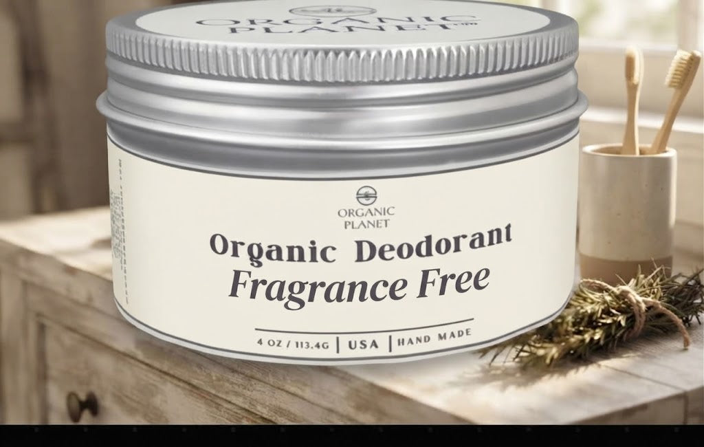 A silver metal tin of Organic Planet Organic Deodorant Fragrance Free, set on a rustic wooden surface next to a small cup of toothbrushes.