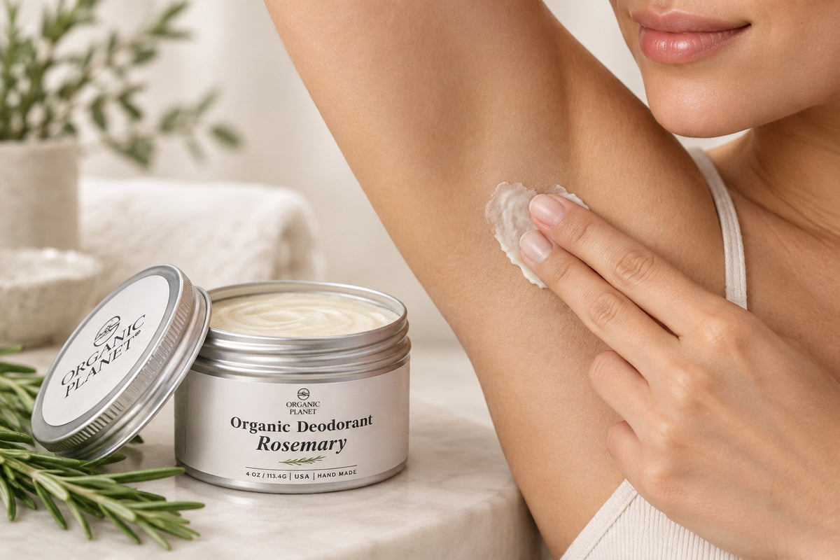 An open silver metal tin of Organic Planet Rosemary deodorant with its lid leaning against it, showing the off-white cream inside on a dark gray background.